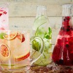 jugs of water with fruit infused in them and ice