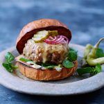 goat meat burger with lettuce, onions and gherkin