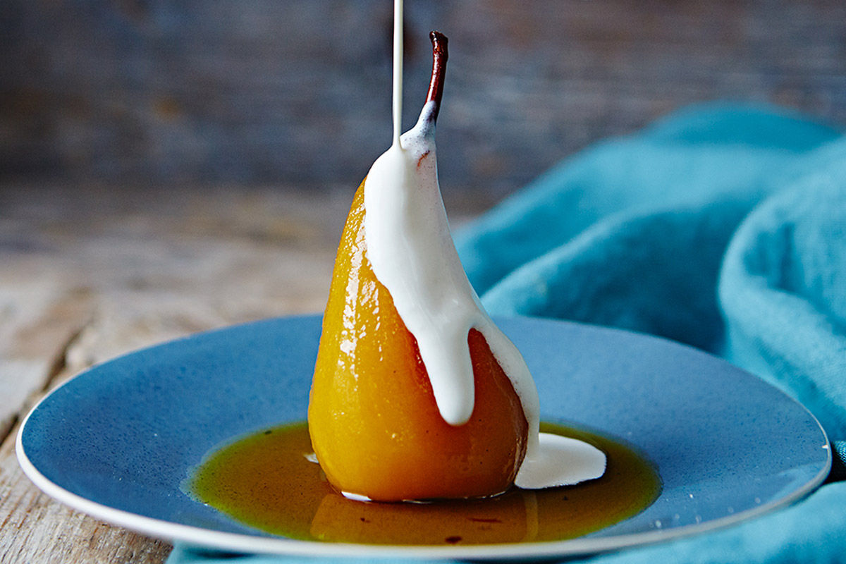 poached pears in sauce with cream on top