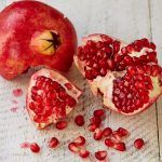 pomegranate cut open with seeds out of it
