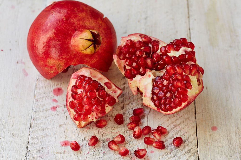 pomegranate cut open with seeds out of it