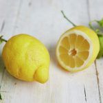 lemon on table and lemon sliced next to it