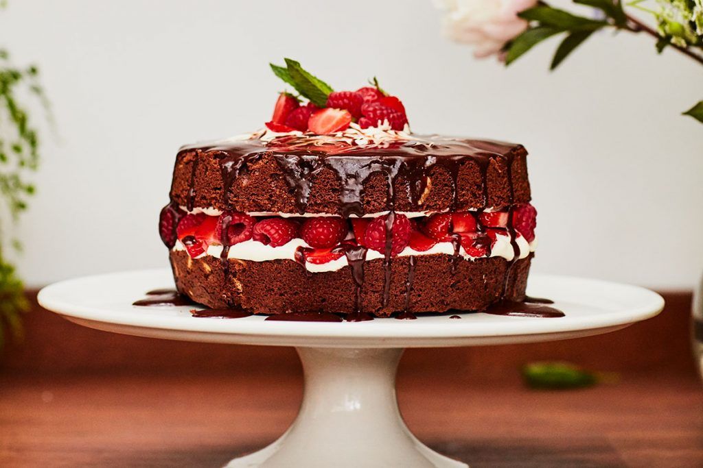 perfect chocolate cake with raspberries, strawberries and cream on top