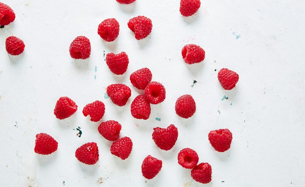 raspberries flat lay scatter on white table