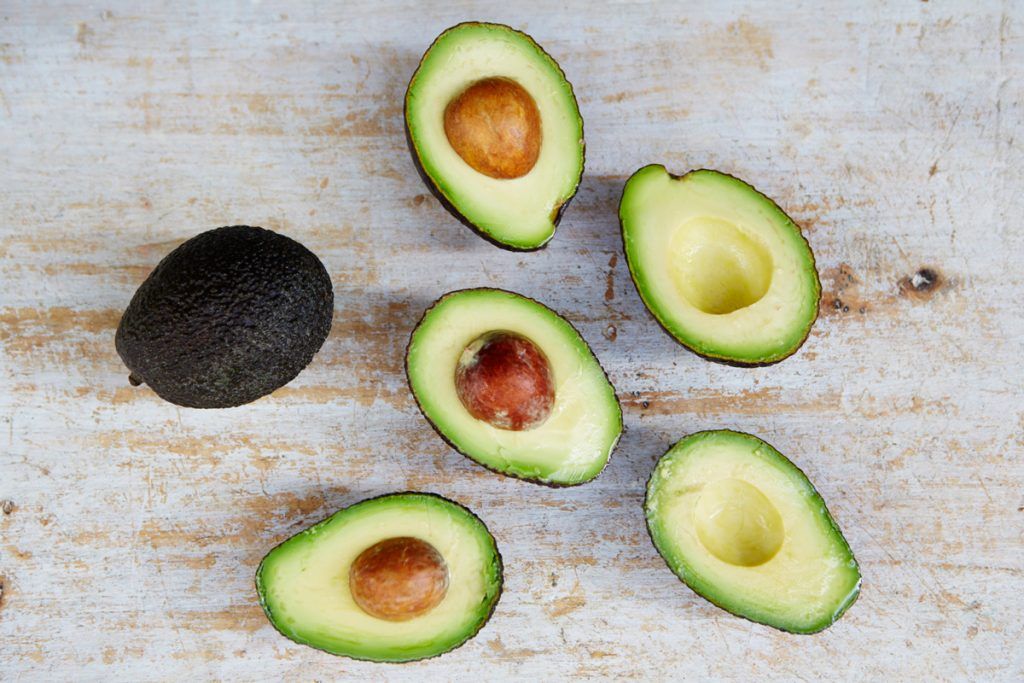 a scatter of avocados cut in half