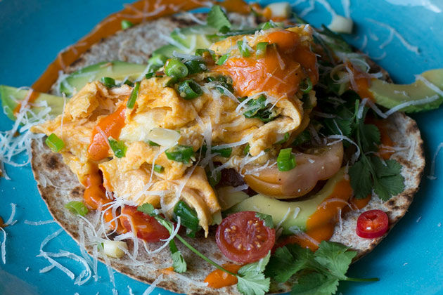 Mexican recipes - flatbread with hot sauce, cheese, tomatoes and herbs