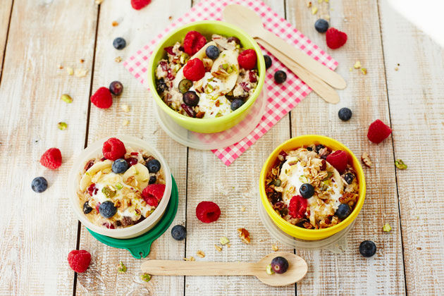 granola and oats breakfast with raspberries and blueberries and yoghurt on top