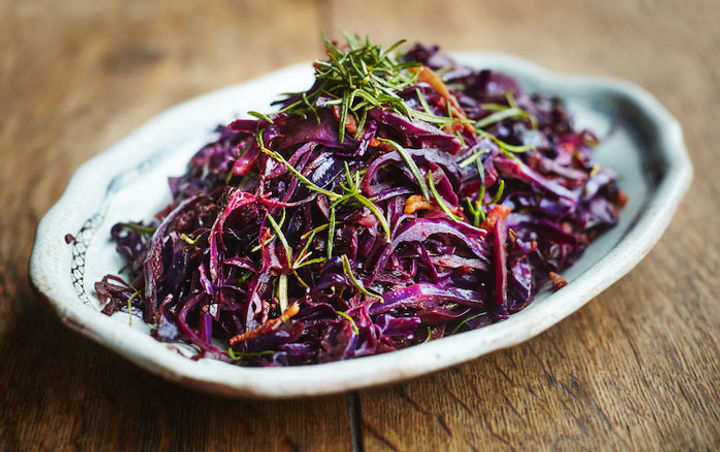 Serving plate of braised red cabbage with rosemary sprinkled on top