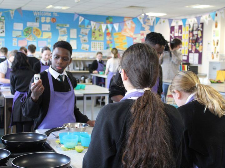 School children learning to cook in their Food Tech classroom
