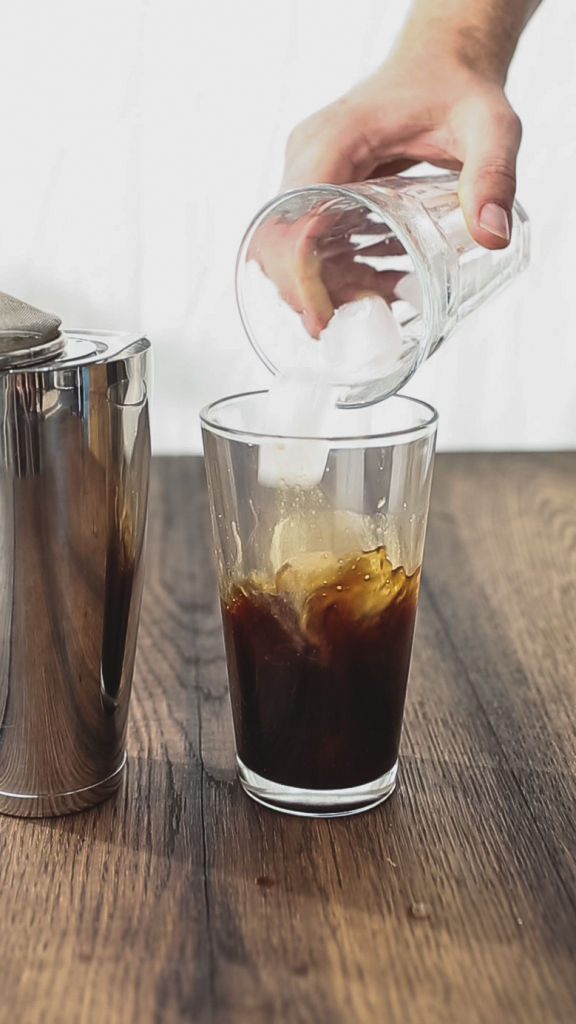 Image of ice being poured into a glass of espresso