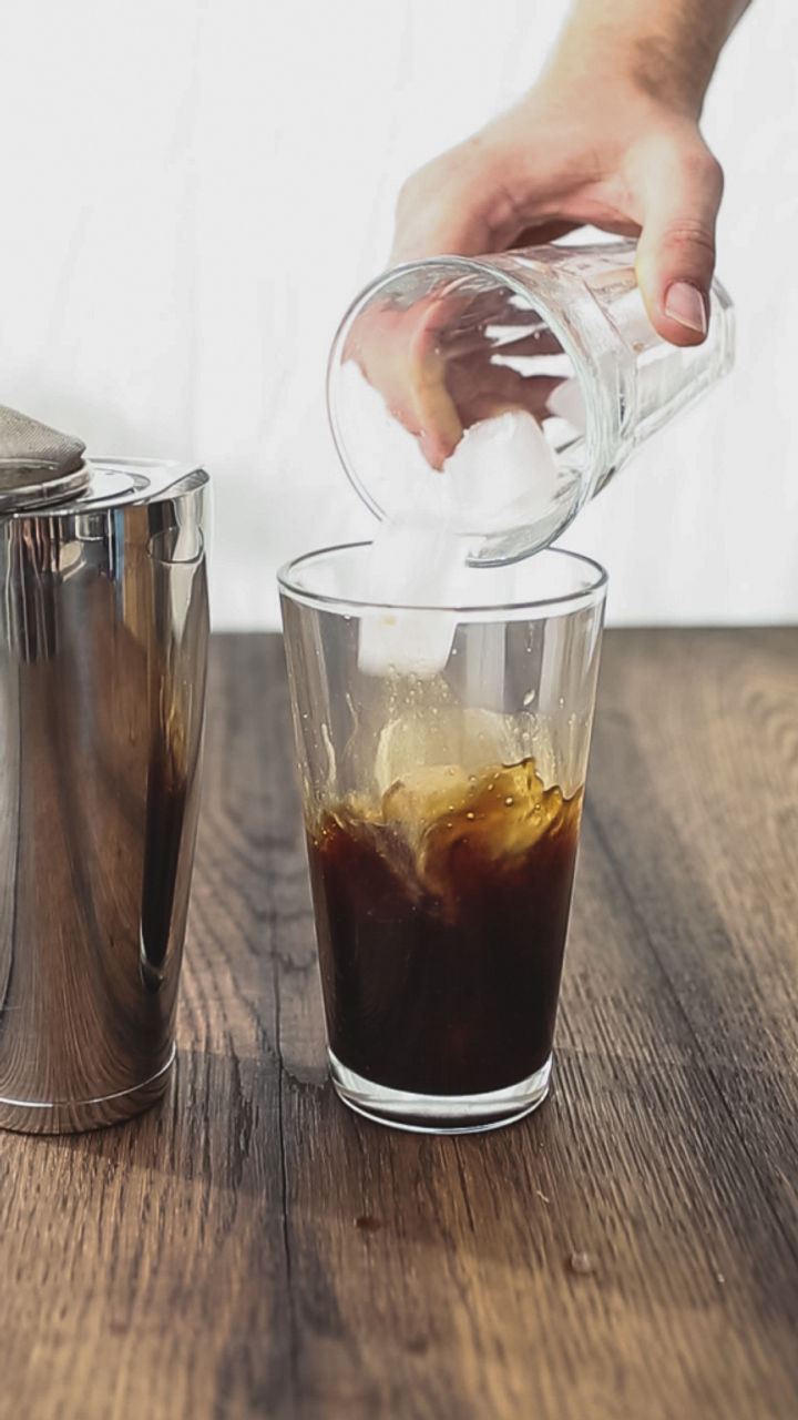 Image of ice being poured into a glass of espresso