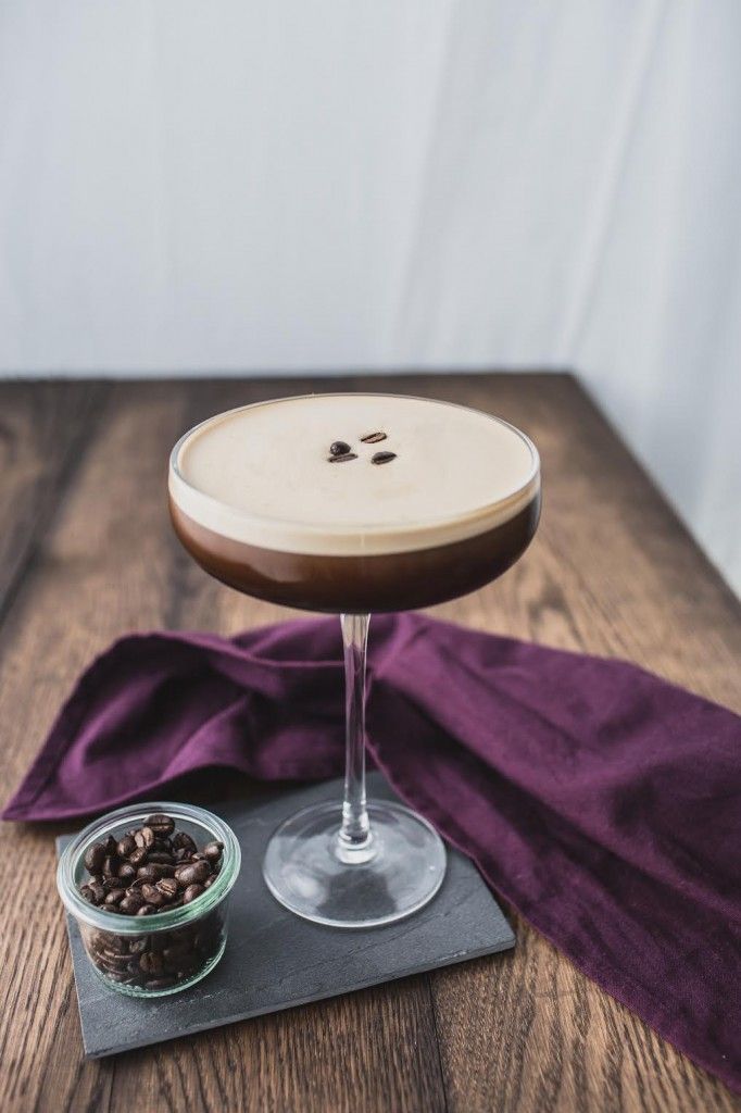 Image of an espresso martini and a small bowl of coffee beans