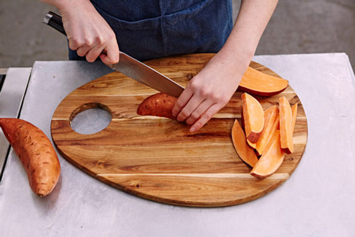Image of sweet potato being cut into wedges