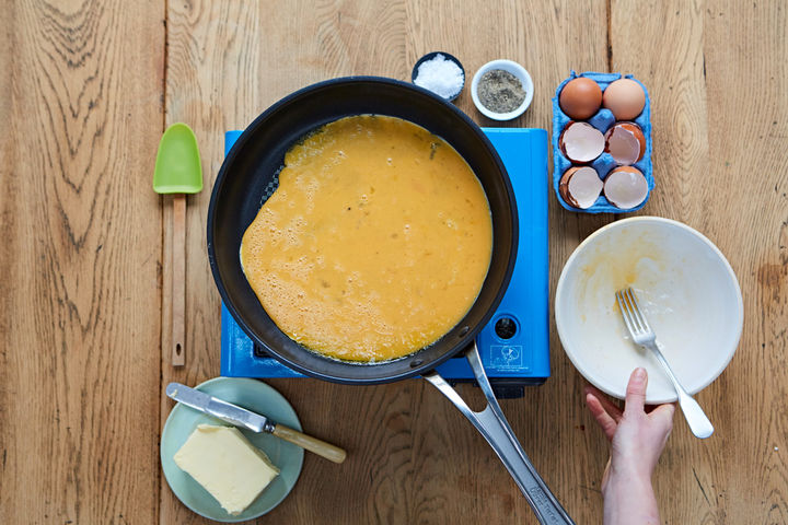 Image of whisked eggs poured into a frying pan