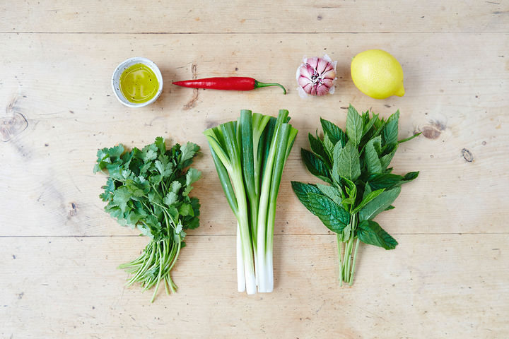 Image of marinade ingredients including lemon, oil, spring onion, chilli, garlic, olive oil, coriander and mint