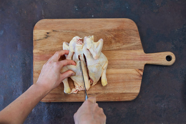 Image of spine being removed from raw chicken 