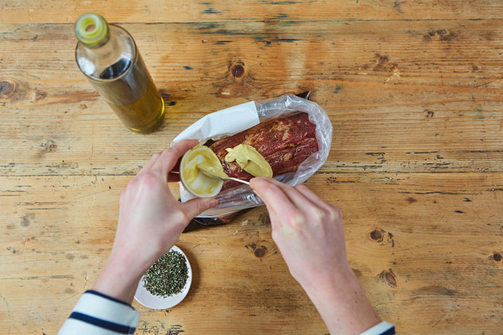 Image of mustard being added to marinade bag with steak