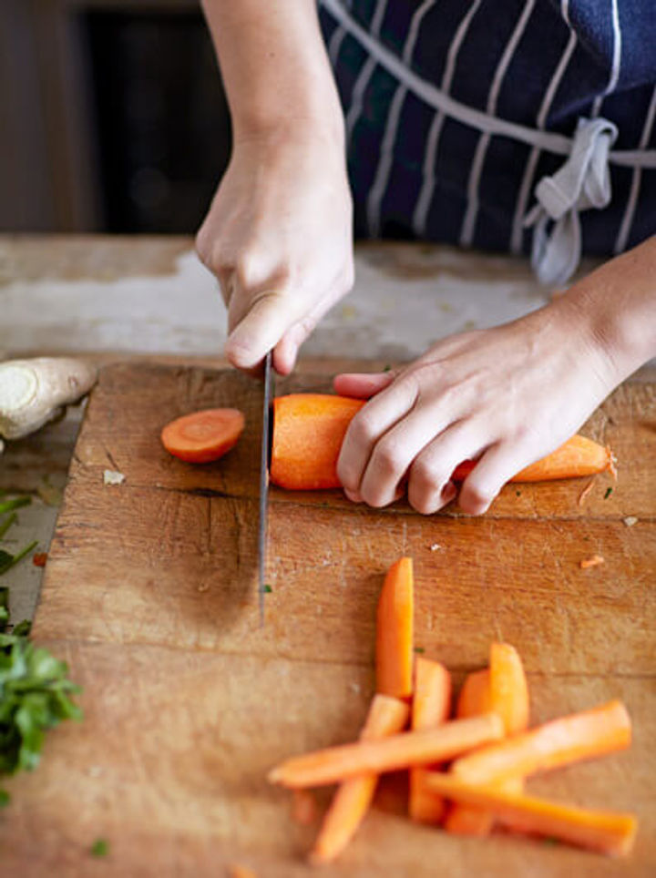 Image of carrots being sliced into large batons.
