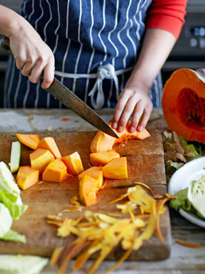 Image of pumpkin being chopped into large pieces