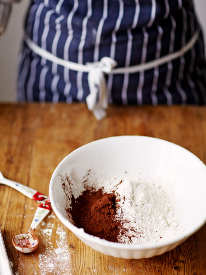 Image of flour, cocoa and baking powder being mixed in a bowl