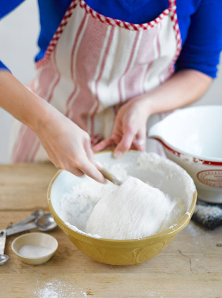 Image of sourdough sponge being mixed with flour and salt